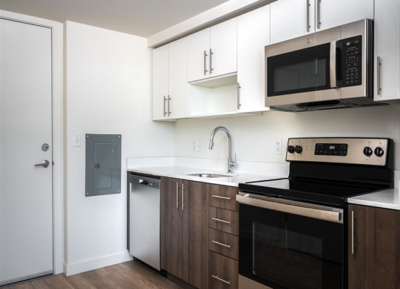 a kitchen with white cabinets and black appliances and a microwave