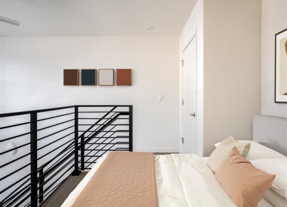 a bedroom with a bed and a railing in a small room