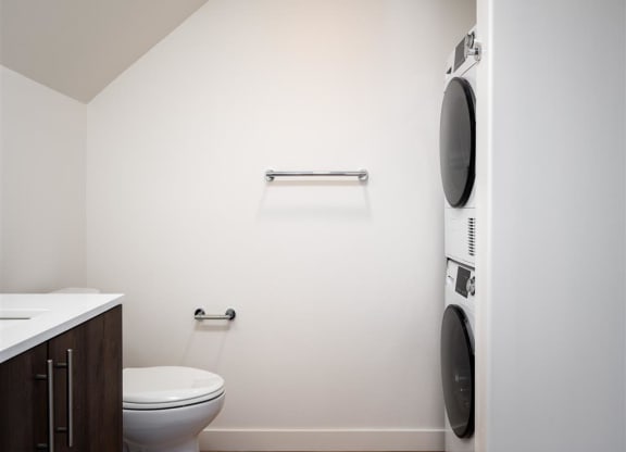 a bathroom with a toilet and a washing machine in it