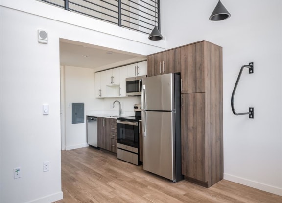 a kitchen with a stainless steel refrigerator and a wooden cabinet