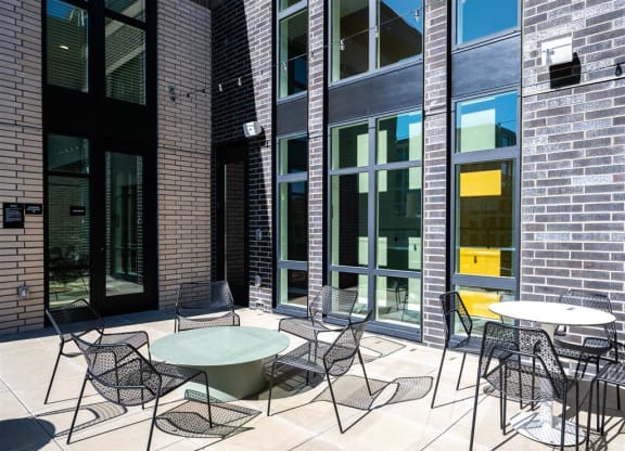 a patio with tables and chairs outside of a building