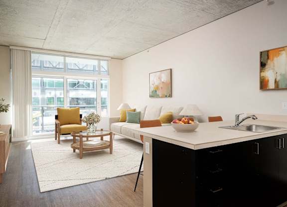 a living room with a kitchen and a large window
