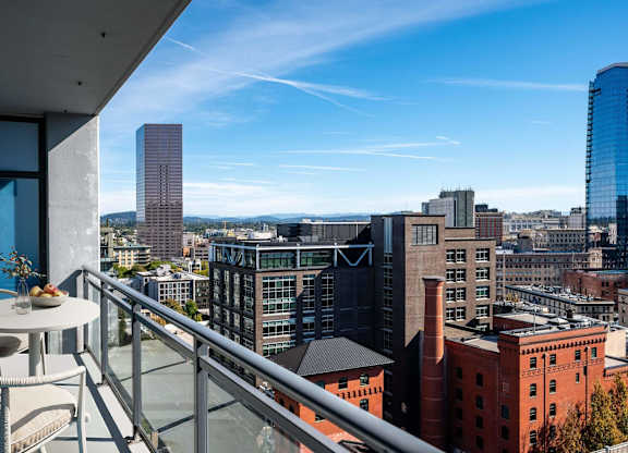 a balcony with a view of the city and a table and chairs