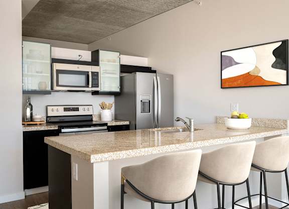a kitchen with an island and a counter with chairs