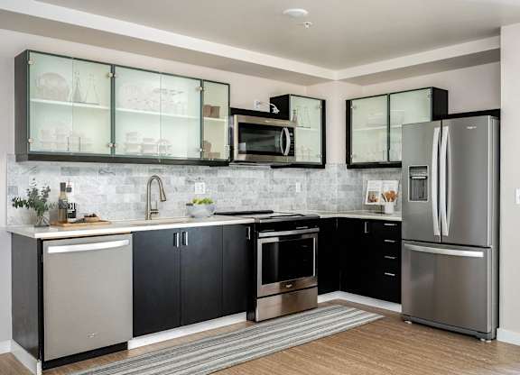 a kitchen with stainless steel appliances and black and white cabinets