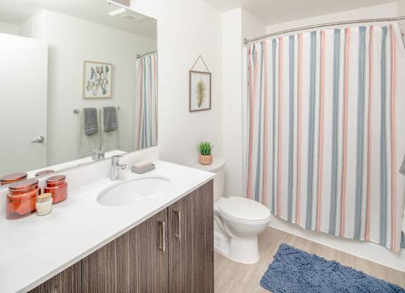 A bathroom with a striped shower curtain and a white toilet.