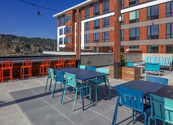 A patio with blue chairs and tables.