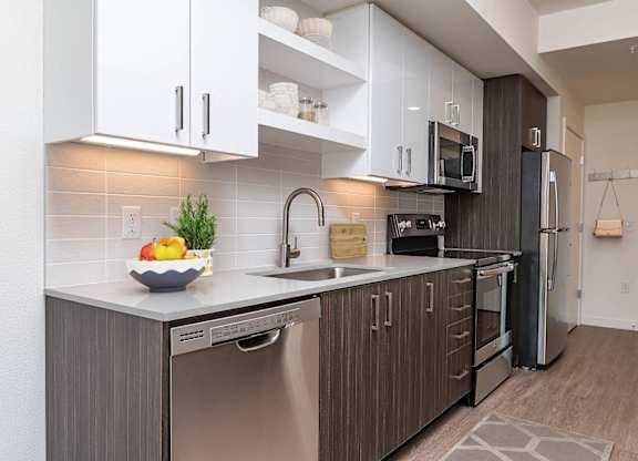 A modern kitchen with stainless steel appliances and wooden cabinets.