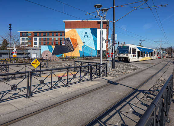A train is on the tracks in front of a colorful building.