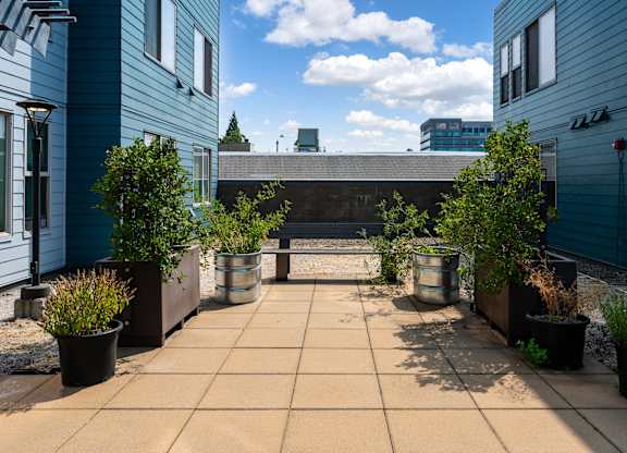a patio with potted plants and a bench
