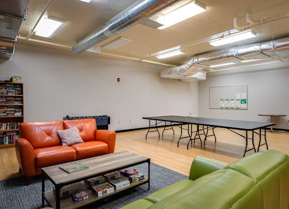 a game room with a ping pong table and couches