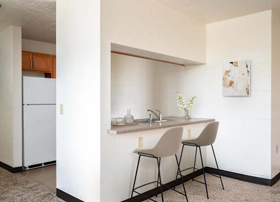 a small kitchen with a counter and two stools