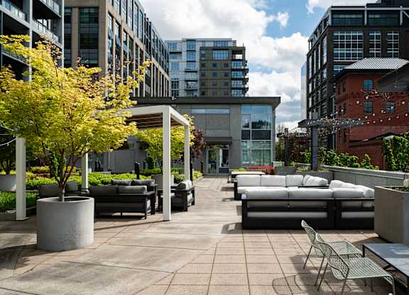 A patio with a table and chairs is surrounded by buildings.