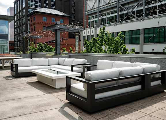 A white couch and table set on a patio.