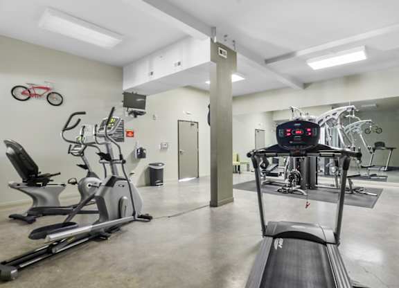 A gym with treadmills, exercise bikes, and other equipment.