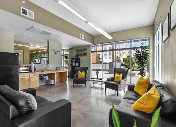 A black couch with yellow pillows sits in a modern living room.