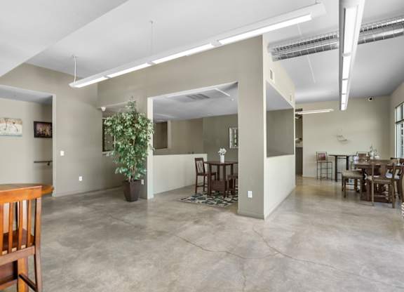 A spacious living room with a dining area and a kitchenette.