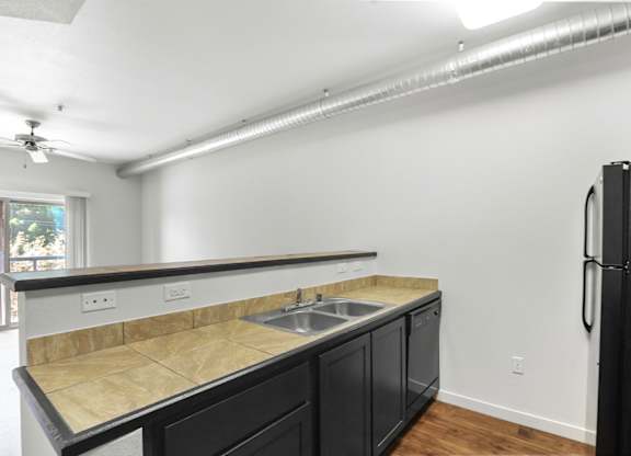 A kitchen with black cabinets and a granite countertop.