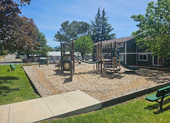 A playground with a swing set and a slide.