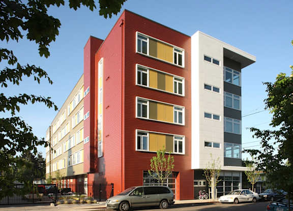 A red and white building with a parking lot in front.