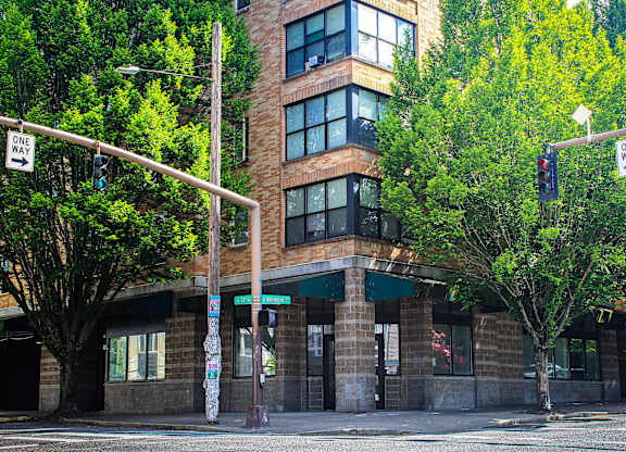 A street view of a building with a one way sign.