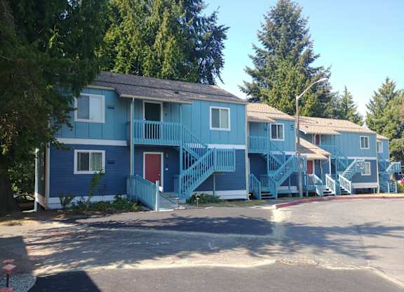 A blue house with a red door and a balcony.