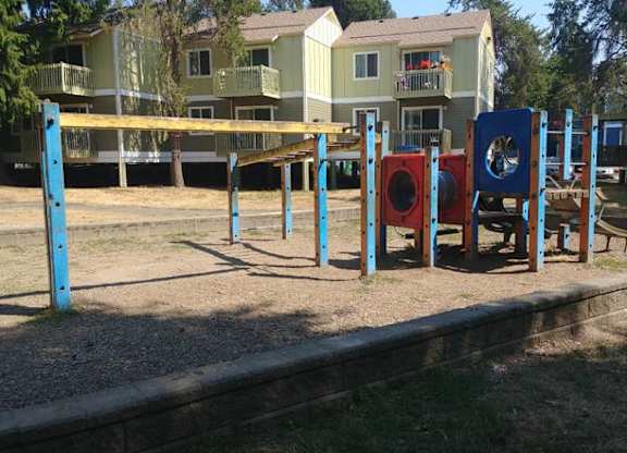 A playground with a blue swing set and red and blue play equipment.