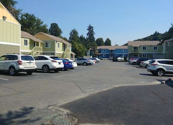A parking lot with cars and apartment buildings in the background.