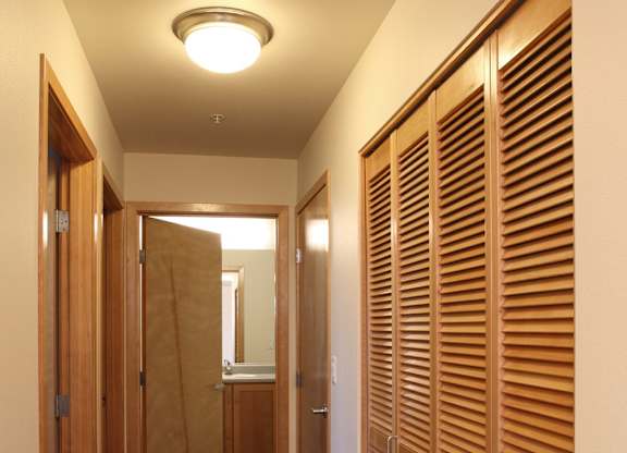 A long hallway with wooden doors on the right.