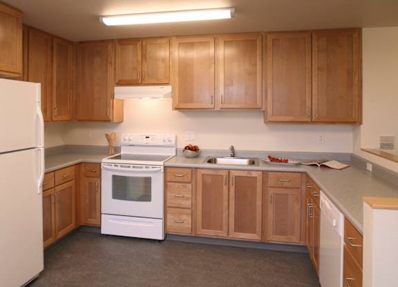 A kitchen with wooden cabinets and white appliances.