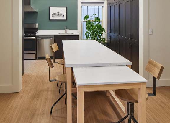 A white table with four chairs in a room.