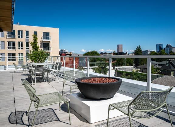 a fire pit on a rooftop terrace with chairs and tables at Slabtown Square Apartments, Oregon, 97209