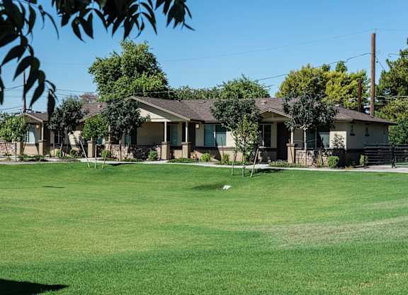 A row of houses with a green lawn in front.