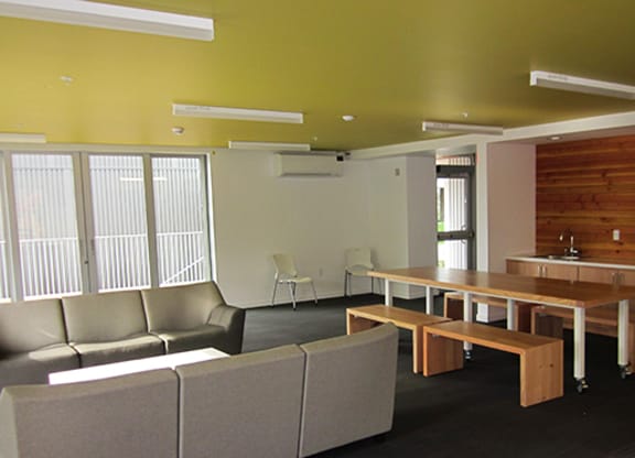 a room with couches a table and chairs and a kitchen