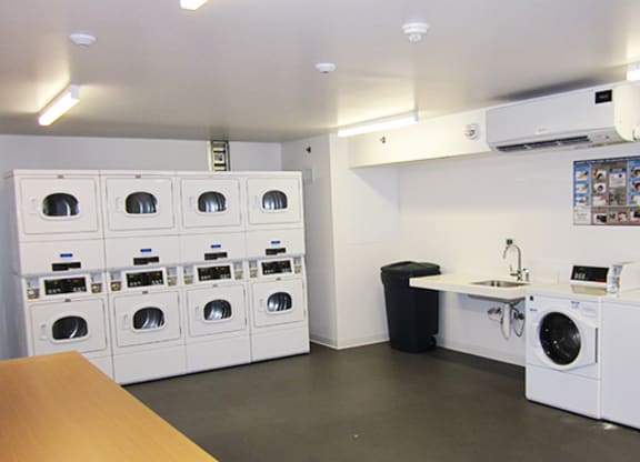a laundry room with washes and dryers and a counter with a counter top