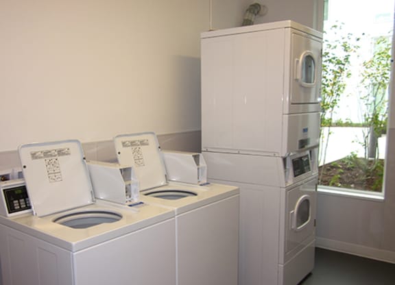 a laundry room with two washing machines and a refrigerator