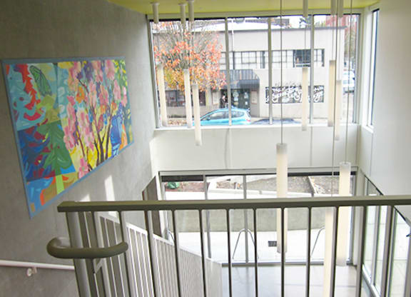 the view from the top of a staircase looking down into a building with a window