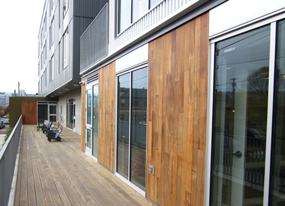 the side of a building with glass windows and a wooden sidewalk