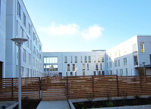 a row of new apartment buildings with a wooden fence