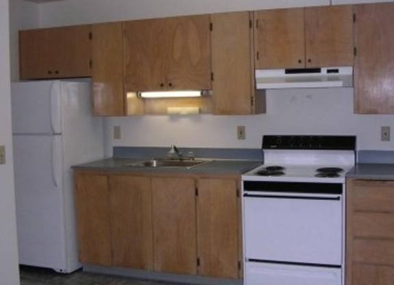 A kitchen with wooden cabinets and white appliances.