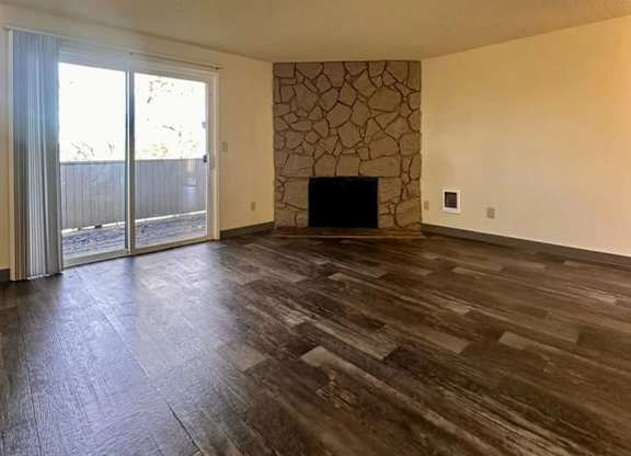 A room with a fireplace and sliding glass doors.