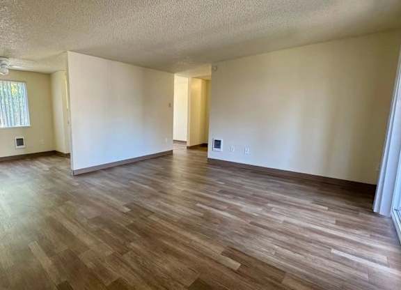A room with wooden flooring and a window.