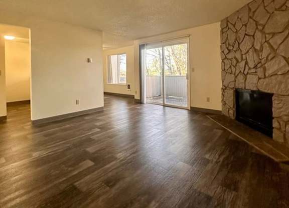 A living room with a stone wall and a flat screen TV.