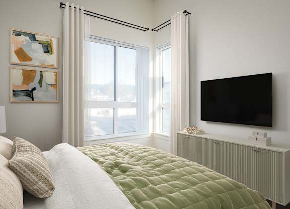 A bedroom with a bed, a television, and two paintings on the wall.