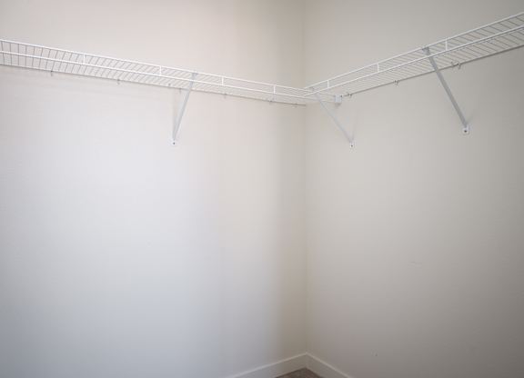A white wall with a metal rack on it.