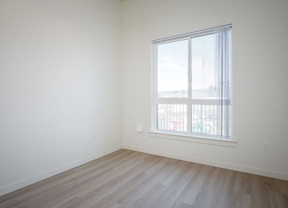 A room with a window and wooden flooring.