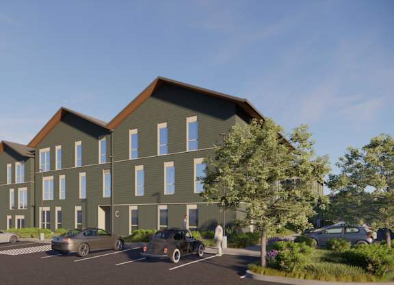 A modern building with a parking lot in front.