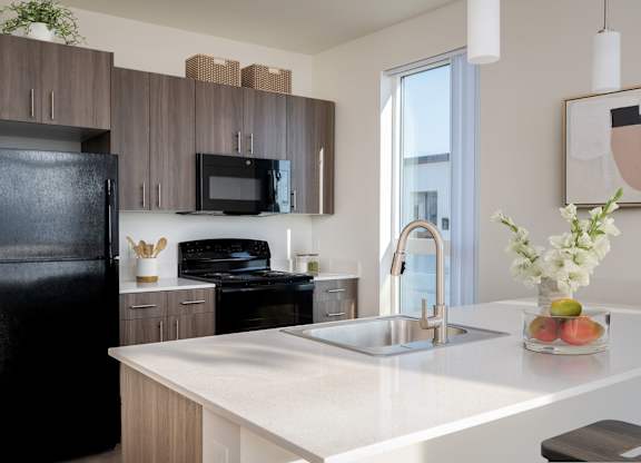 A modern kitchen with a black refrigerator, microwave, and oven.