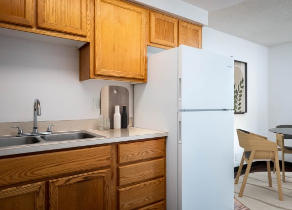a kitchen with a sink and refrigerator and a dining room table