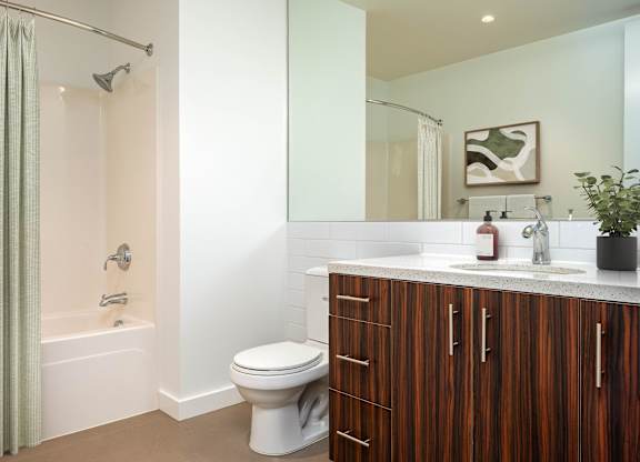 A bathroom with a toilet, sink, and shower.